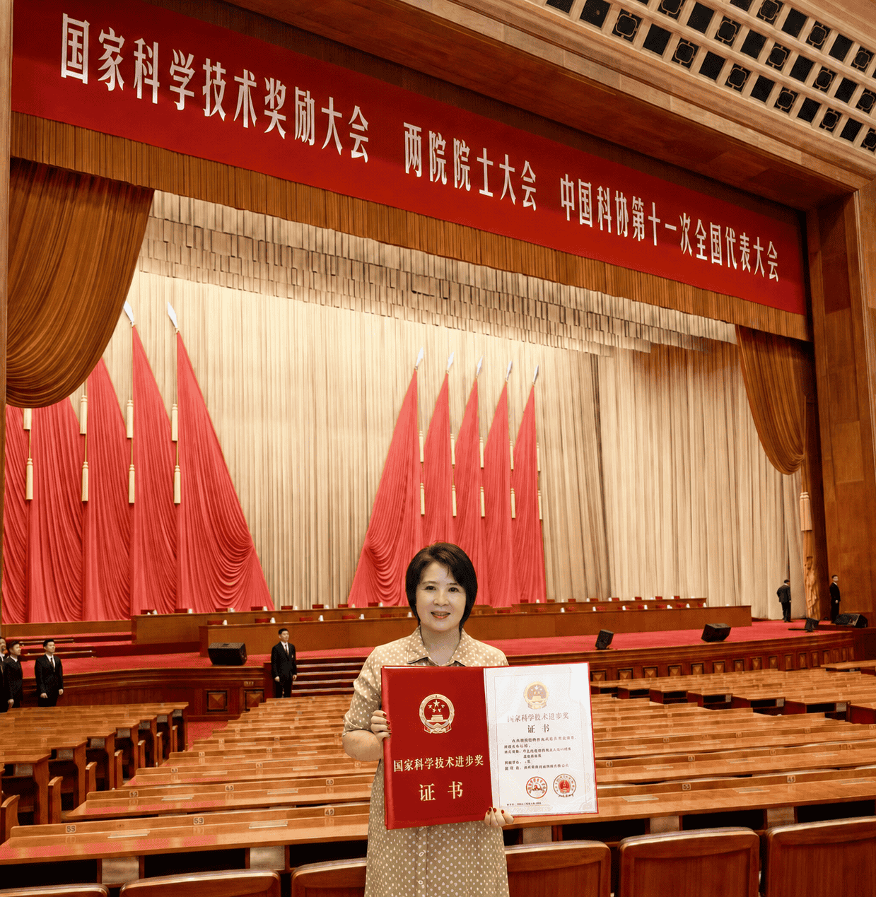 家育种业集团创始人毛区健丽在国家科学技术奖励大会现场手持获奖证书